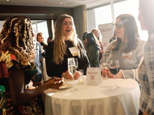 People have a conversation at a Women for UMass event